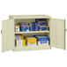 A Tennsco putty storage cabinet with solid doors open to reveal shelves with many boxes.