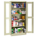A Tennsco putty storage cabinet with C-Thru doors filled with various items.