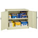 A Tennsco putty storage cabinet with solid doors open to reveal blue and yellow boxes on shelves.