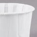 A Solo white paper souffle cup on a gray surface.