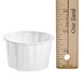 A white Solo portion cup next to a ruler.