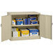 A sand Tennsco jumbo storage cabinet with solid doors open to reveal shelves with blue and white boxes and papers.