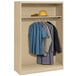 A sand Tennsco open-style wardrobe cabinet with clothes inside.