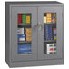 A dark gray Tennsco storage cabinet with C-Thru doors.
