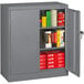 A dark gray Tennsco metal storage cabinet with solid doors and shelves full of books.