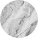 An Enjay round laminated chipboard charcuterie board with a white marble surface and black veins.