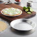 A pie in a Choice aluminum pie pan on a cutting board.