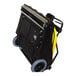 A black and yellow Tornado wide area vacuum cleaner on a portable cart with wheels.