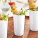 A group of Choice white plastic cups with food on them.