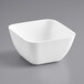 A white square bowl on a gray surface.