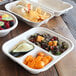 A table with World Centric compostable containers filled with a variety of food.