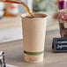 A person pouring coffee into a World Centric natural compostable paper cup.