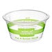 A clear plastic World Centric portion cup on a counter with a green World Centric label.