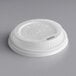 A white plastic World Centric travel lid for paper hot cups with a hole in the top.