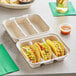 A white World Centric 3-compartment fiber taco container with tacos inside.