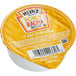 A yellow Heinz Honeyracha portion cup with a label.