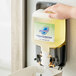 A hand holding a Safeguard foaming soap dispenser.