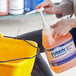 A person pouring Dawn Professional floor cleaner into a bucket.