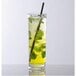 A customizable clear plastic Tom Collins glass filled with a drink and a straw.