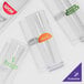 A clear plastic container holding a set of 24 clear plastic Tom Collins glasses with green customizable text.