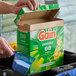 A box of Gain original powder laundry detergent with a scoop of detergent being removed.