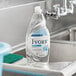 A bottle of Ivory Ultra Classic Original dish soap on a stainless steel sink counter in a school kitchen.