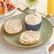 A plate with two bagels and a bowl of Spicy Jalapeno Pepper Cream Cheese Spread.