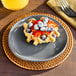 An American Metalcraft Crave Storm Coupe Melamine Plate with a waffle topped with strawberries and blueberries.