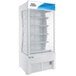 An Avantco white refrigerated air curtain merchandiser with shelves.