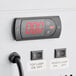 The digital display on a white Avantco countertop freezer with red numbers.