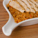 A CAC white fry pan plate with rice and meat on it.