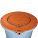 An orange round lid with a metal base for a Thermaco Trapzilla grease interceptor.