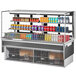 A Turbo Air white drop-in refrigerated display case with cans of soda on shelves.