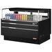 A black Turbo Air horizontal refrigerated open curtain merchandiser with drinks and cans inside.