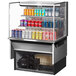 A Turbo Air stainless steel drop-in refrigerated display case with drinks and cans inside.