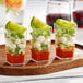 A group of Choice clear plastic mini cups filled with vegetables and cheese.