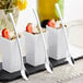 A close-up of a white container with strawberries and a Visions silver plastic tasting spoon inside.