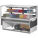 A Turbo Air white drop-in refrigerated display case with cans of soda and different flavored drinks.