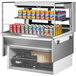 A Turbo Air white drop-in refrigerated open display case with cans of soda on a shelf.