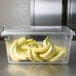 A Rubbermaid clear polycarbonate food storage box with bananas inside.