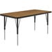 A rectangular table with a medium oak top and black legs.