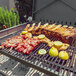 A Nuke BBQ Pampa grill with meat and lemons on it.