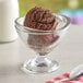 A glass bowl of brown Oringer Double Dutch chocolate ice cream with a spoon.