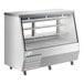 An Avantco stainless steel refrigerated double-duty deli case with glass shelves on wheels.