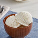 A wooden bowl of Oringer pineapple ice cream with a spoon.