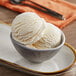 A bowl of vanilla ice cream with a scoop of Oringer Peppermint Hard Serve Ice Cream Flavoring.