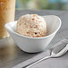 A bowl of Oringer pudding hard serve ice cream with a spoon next to a cup of coffee.