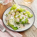 An Acopa grey matte stoneware plate with a salad and a fork on it.