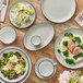 An Acopa Embers grey matte stoneware plate on a table with food.