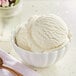 A bowl of Oringer Rum hard serve ice cream with a spoon on a white background.